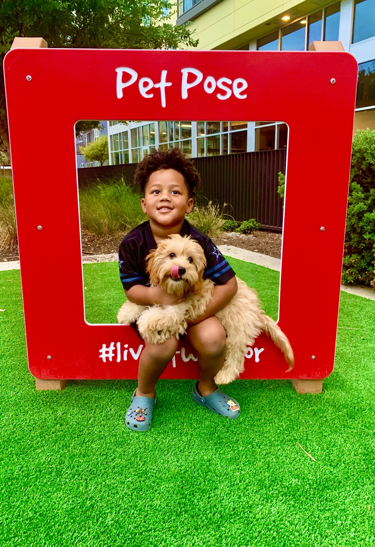 Young boy holding an apricot Cavapoo puppy at a Pet Pose photo frame